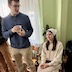 Photo from the open house at the rectory. A young man is standing in the left half of the frame with a young woman seated next to him in the right half.