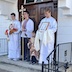 Photo of the four altar servers standing outside, in front of the entrance to the church.