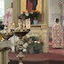 A photo of part of the iconostasis with Fr. Aleksey partially visible through the open Royal Doors, and a young altar boy visible through the open door on the right. Their backs are facing the camera.